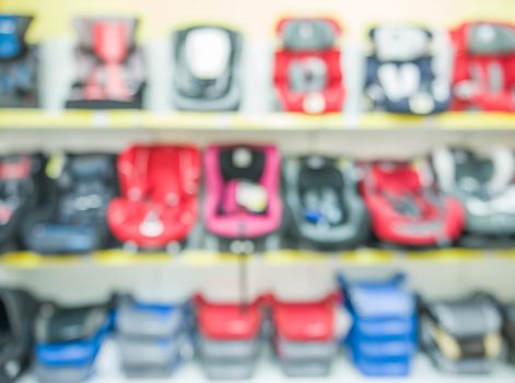 Children car seats in the store. Blurred image as abstract background