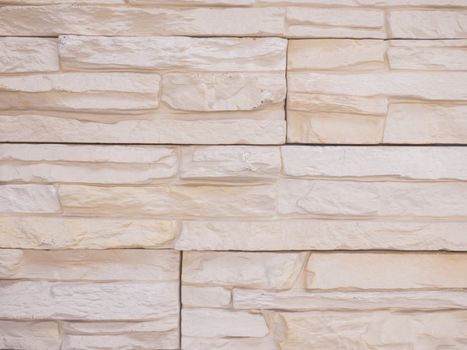 a wall from an artificial gray stone facade with rough fractured surfaces