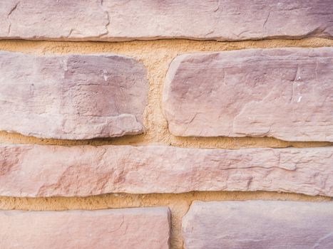 a wall from an artificial gray stone facade with rough fractured surfaces