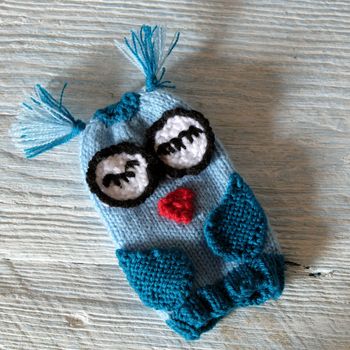 Hand puppets for children day, colorful owl puppet knit from yarn, funny handmade gift for child day on white wooden background