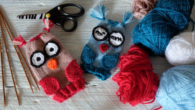 Hand puppets for children day, colorful owl puppet knit from yarn, funny handmade gift for child day on white wooden background