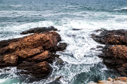 Seascape with stormy waves and dramatic rocks