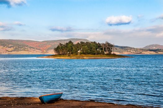 Autumn landscape with a lake, an island and a boat