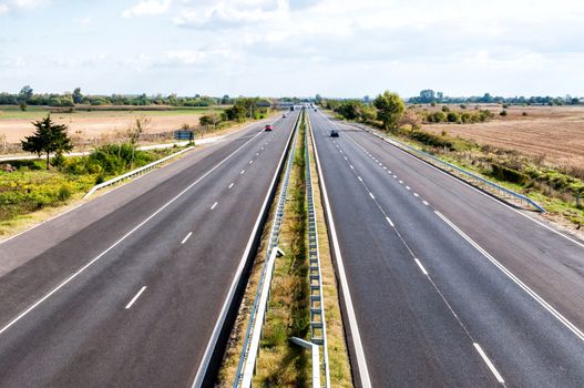 Highway traffic and fields in a sunny day