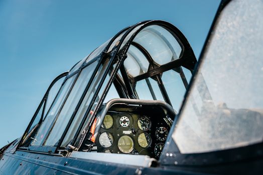 Open vintage airplane cockpit, blue sky background. 