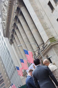 New York City, United States of America - March 26: Businessmen talking on Wall street in front of New York Stock Exchange on March 26, 2015.