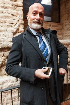 Businessman middle-aged bearded and suit jacket searching on tablet on a blurred background