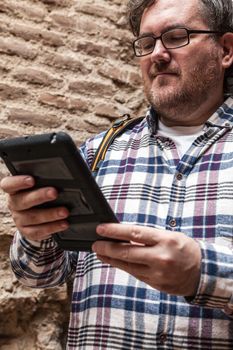 Young man with glasses in looking his mobile device