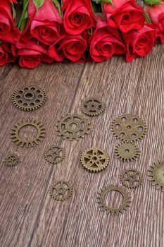 Roses and gears on a brown wooden background