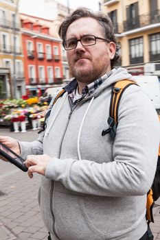 Young man with glasses in looking his mobile device
