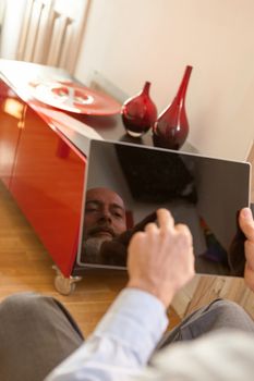 Businessman middle-aged bearded and suit jacket searching on tablet on a blurred background