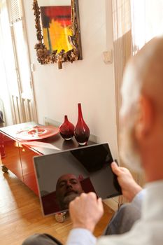 Businessman middle-aged bearded and suit jacket searching on tablet on a blurred background