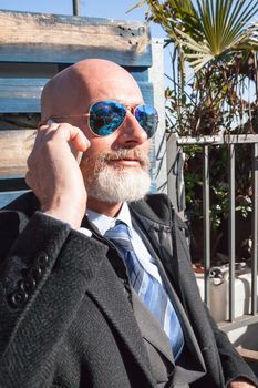 Middle-aged man , handsome and elegant working outside the office in a relaxed atmosphere