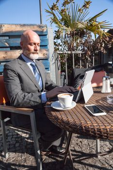 Middle-aged man , handsome and elegant working outside the office in a relaxed atmosphere