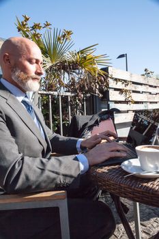 Middle-aged man , handsome and elegant working outside the office in a relaxed atmosphere