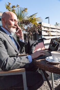 Middle-aged man , handsome and elegant working outside the office in a relaxed atmosphere