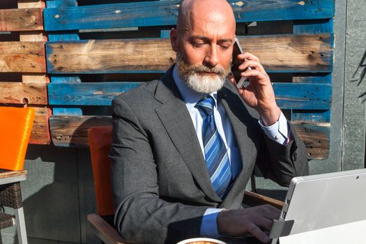 Middle-aged man , handsome and elegant working outside the office in a relaxed atmosphere