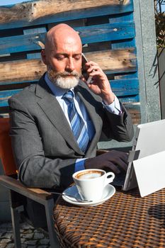 Middle-aged man , handsome and elegant working outside the office in a relaxed and atmosphere