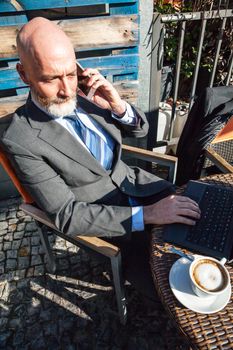Middle-aged man , handsome and elegant working outside the office in a relaxed and atmosphere