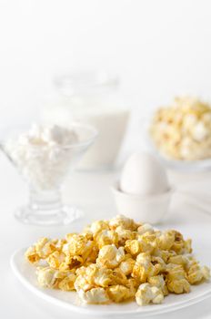 Breakfast white on white, high key and bokeh. A bowl of popcorn, eggs, cheese and milk.