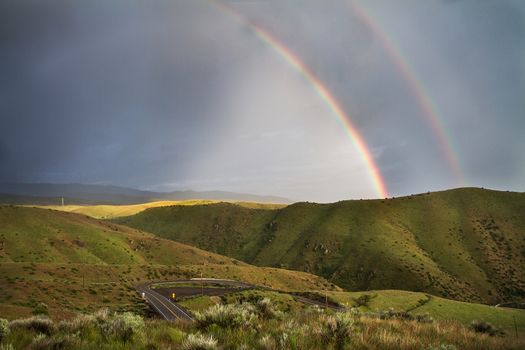 Stormy weather in the mountains with a road in the forground.