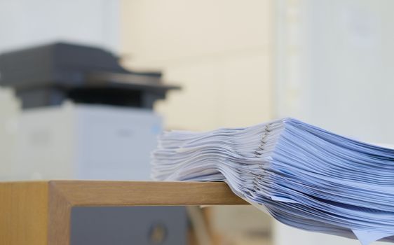 Stack of document is organized on desk after printing in office.