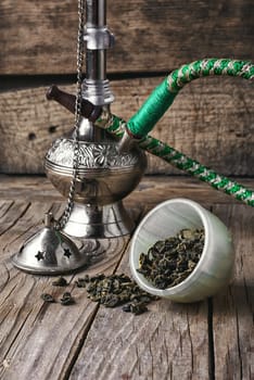 Arab hookah metal and scattered tobacco leaf