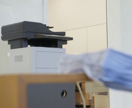Printer for photocopy is placed in front of room in office.