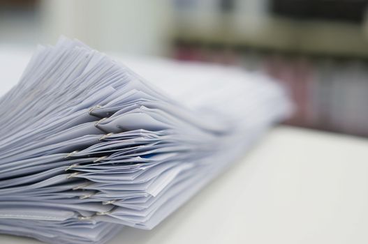 Stack of data document  are organised on desk in office.