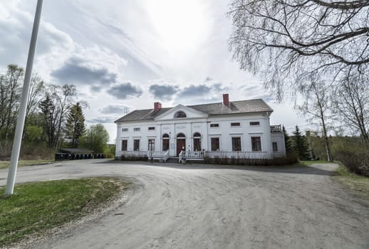 Baggbole Mansion in Spring with a partly cloudy sky.