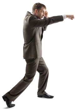 A man in suit punching and standing on white background