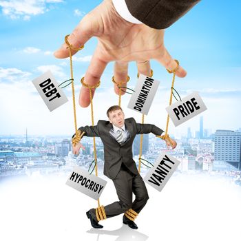 Image of businessman hanging on strings like marionette with words among clouds