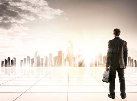 Businessman standing with back against morning city panoramic view