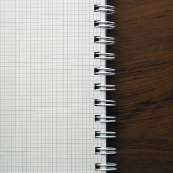 Blank notebook paper on wooden desk background