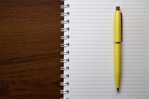 Blank notebook paper on wooden desk background