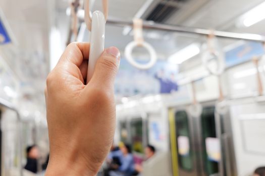 close up of hand holding Handles in Subway Train