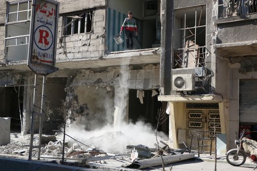 SYRIA, Saqba : A resident of the city of Saqba cleans a destroyed building of the city of East suburb of Damascus, the capital city of Syria, on December 28, 2015. Regime forces fired rockets on the towns of Douma, Harasta, Saqba and Arbin in the opposition-held Eastern Ghouta region on December 13, 2015 according to the Syrian Observatory for Human Rights. At least 45 people were killed during these attacks, according to the NGO. 