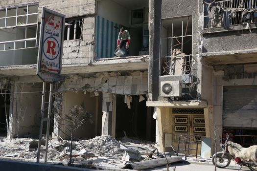 SYRIA, Saqba : A resident of the city of Saqba cleans a destroyed building of the city of East suburb of Damascus, the capital city of Syria, on December 28, 2015. Regime forces fired rockets on the towns of Douma, Harasta, Saqba and Arbin in the opposition-held Eastern Ghouta region on December 13, 2015 according to the Syrian Observatory for Human Rights. At least 45 people were killed during these attacks, according to the NGO. 