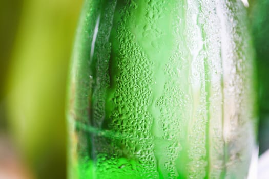 Green glass bottle with condensation on it