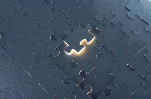 Grey puzzle background with flying piece, close up view