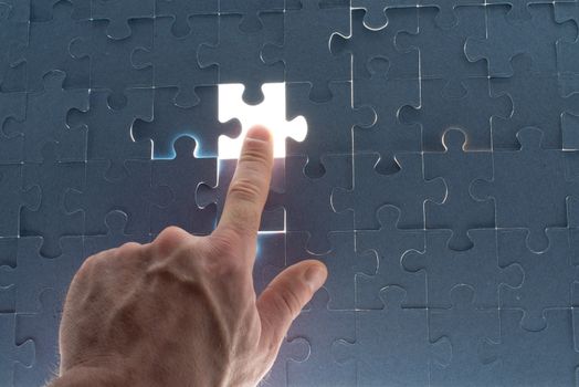 Missing jigsaw puzzle piece with light glow, for completing the final puzzle piece