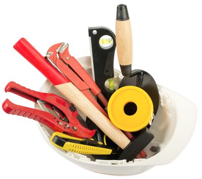 Construction worker supplies including  white hard hat on isolated white background, closeup