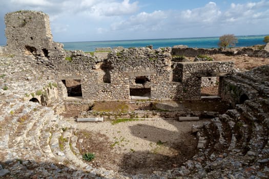 View of historical old amphitheater in Anemurium ancient city in Mersin, on cloudy blue sky background.