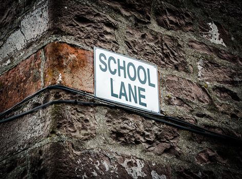 A Sign With School Lane On The Side Of A Building In The UK