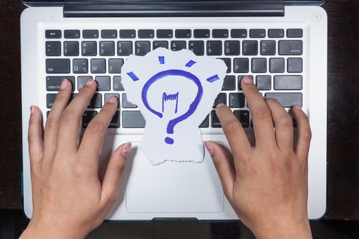 business, education, idea, inspiration and people concept - close up of female hands with paper sheet on computer keyboard