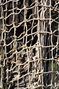 Old fishing net hanging on log as background