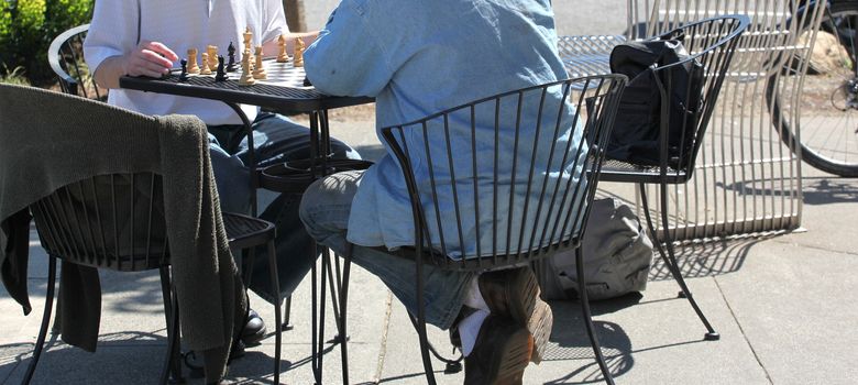 Two men playing a game of chess outdoors.