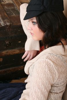 Beautiful brunette teen sitting next to an antique trunk