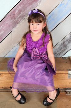 Brunette toddler girl against a colorful background