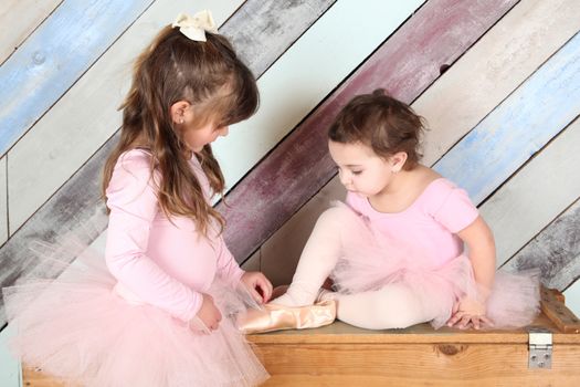 Friends playing dress-up in ballet costumes against colorful background